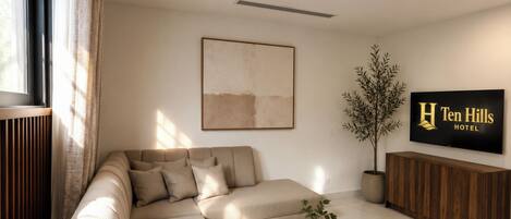 A modern living room with a sectional sofa, a coffee table, and a TV mounted on the wall.