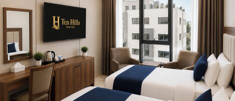 A hotel room with two beds, a desk, a chair, a television, and a view of buildings outside.