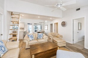 A spacious living area with a sofa set, a wooden coffee table, and a ceiling fan. - Dock, Boat Lift & Golf Cart on Alligator Point (Alligator Point)