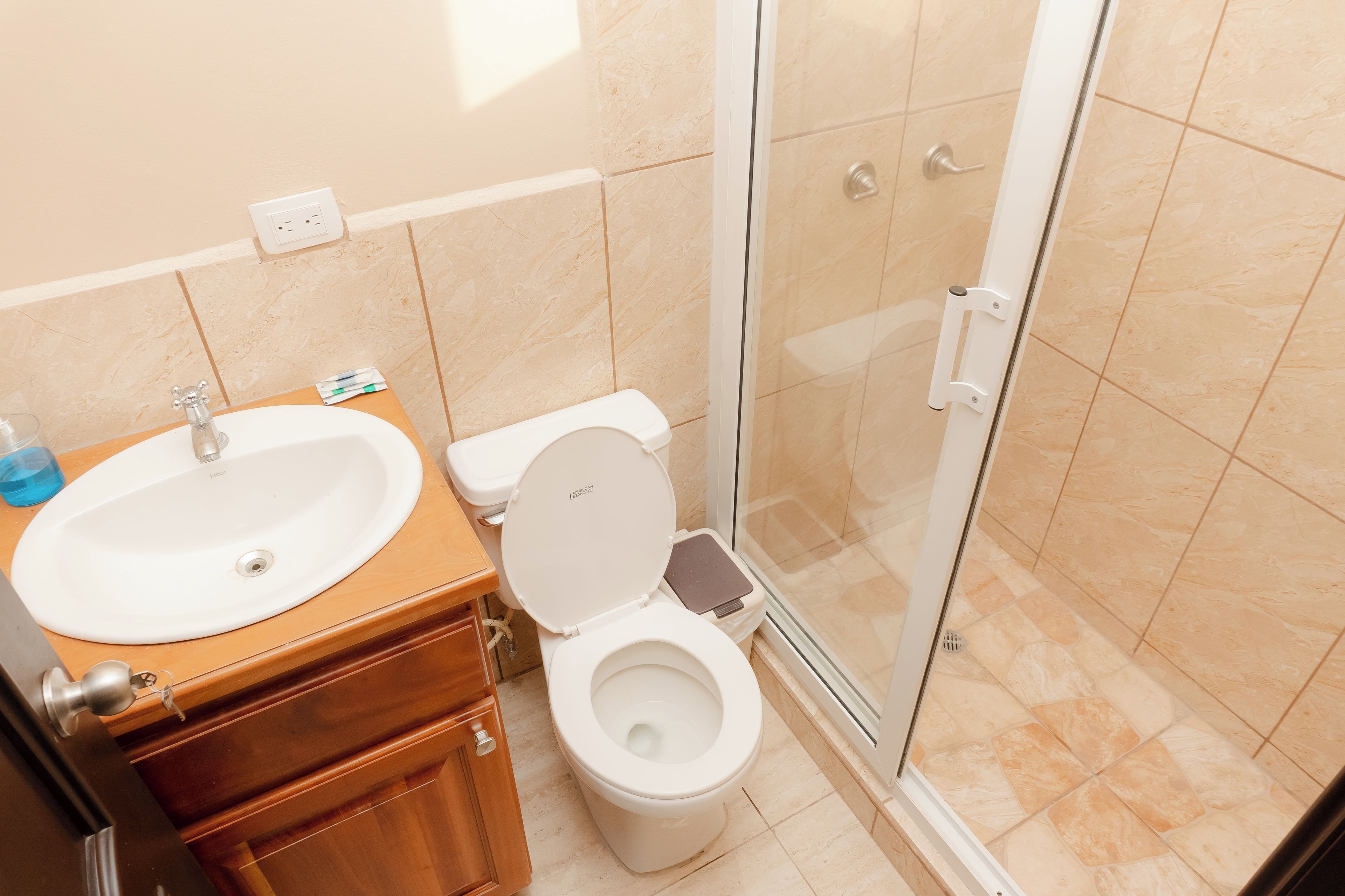 A bathroom with a sink, toilet, and shower area.