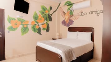Un dormitorio con una cama, aire acondicionado de pared y un mural de flores y un pájaro.