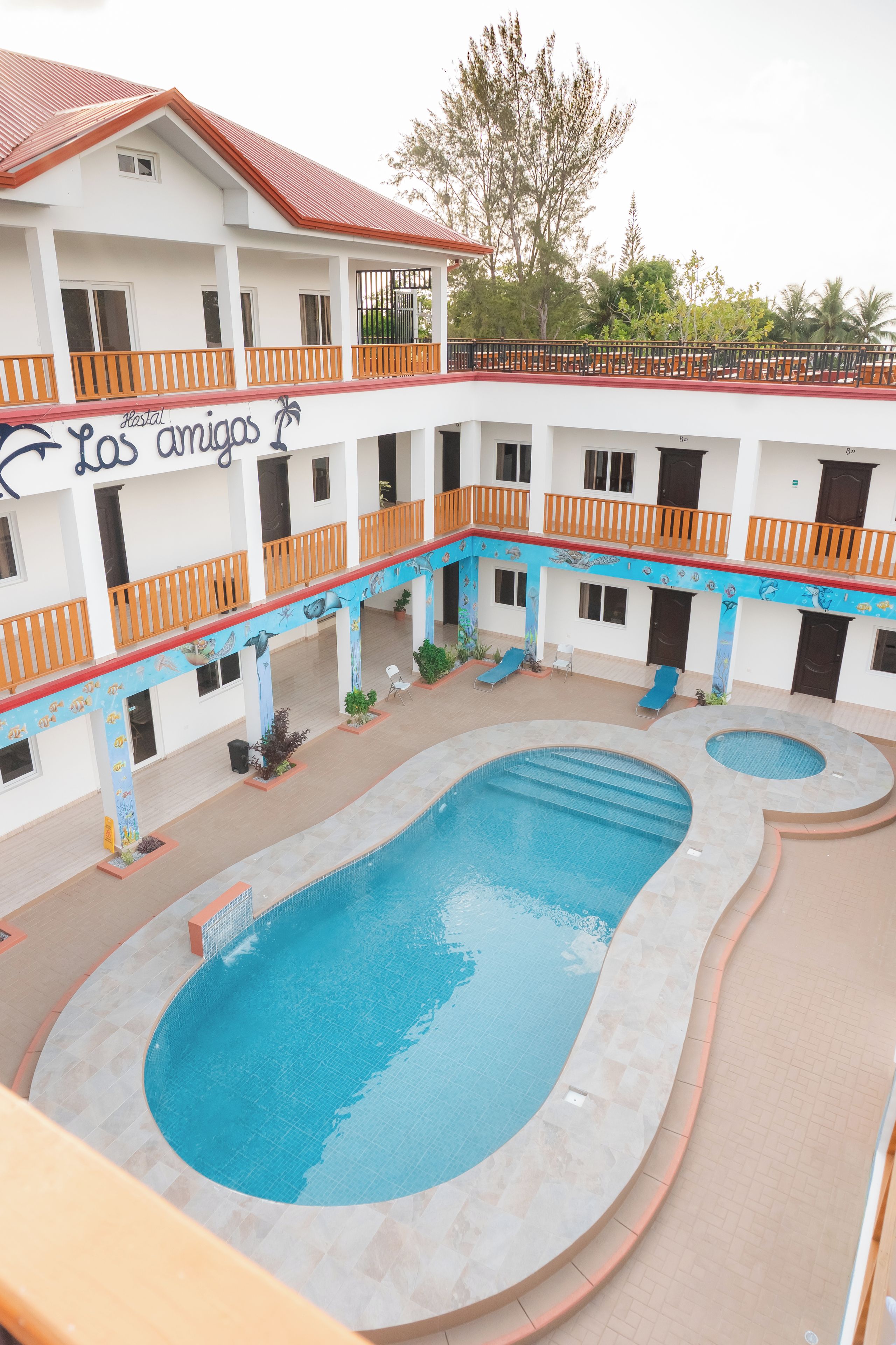 Ett hotell med flera balkonger, en swimmingpool och ett takförsett utomhusområde.