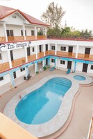 Un hotel con varios balcones, piscina y un espacio al aire libre cubierto.