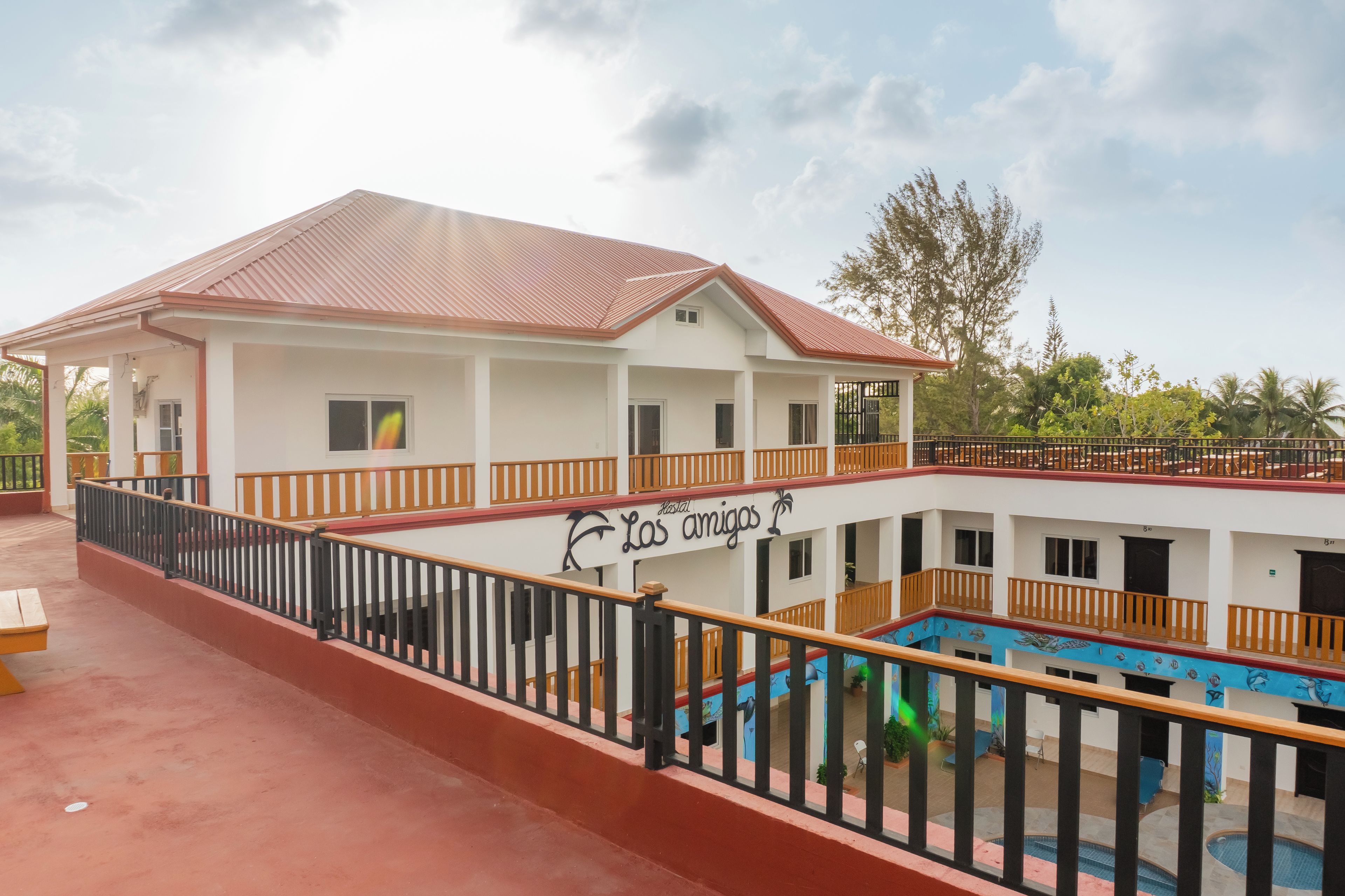A multi-story building with a swimming pool, balconies, and a sign reading 'Las Amigas'.