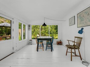 Une pièce comprenant une table à manger, des chaises, une lampe et une carte accrochée au mur.