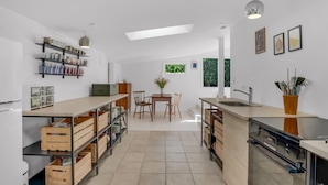 A modern kitchen with a central island, wooden storage, and a dining area with natural light. - "Franki" - 1.8km from the sea by Interhome (Faxe)