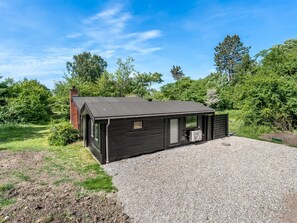 A modern, single-story building with a dark exterior, a chimney, and a gravel driveway. - "Franki" - 1.8km from the sea by Interhome (Faxe)