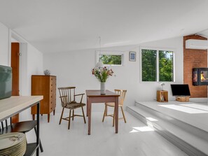 A modern living room with a dining area, a fireplace, and large windows. - "Franki" - 1.8km from the sea by Interhome (Faxe)