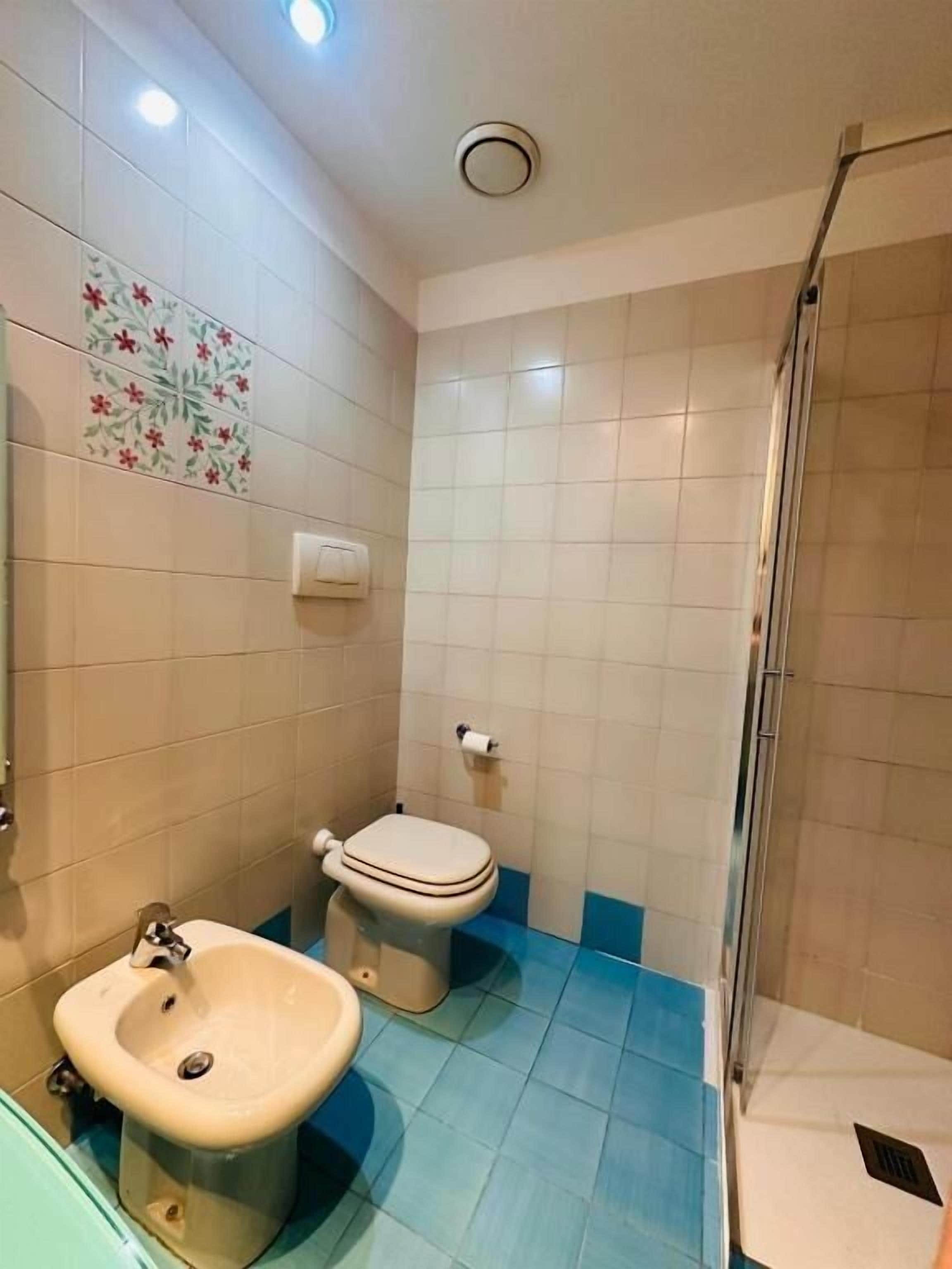 Un baño con inodoro, bidé y lavamanos.
