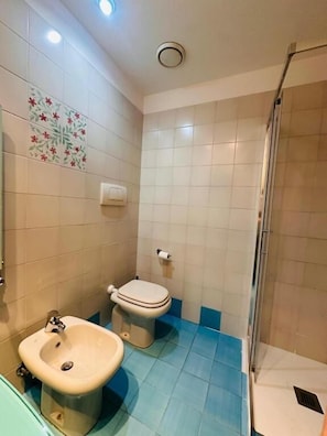 Uma casa de banho com sanita, bidé e lavatório.