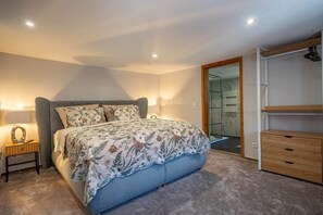 Un dormitorio con cama, mesita de noche, lámpara y armario.