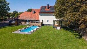 A residential property with a swimming pool, a stone sauna, and a modern house with a red-tiled roof. - Elementa Lodges Wernigerode-Reddeber (Reddeber)
