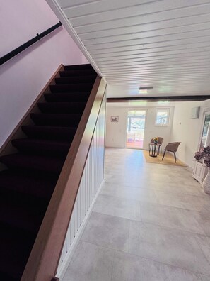 A staircase leading to a landing with a view of the outdoors.