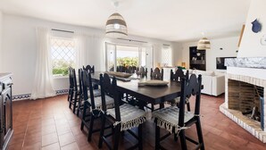 A dining area with a large table, chairs, and a fireplace. - New Listing | Exclusive Ocean View Villa | 2Min to Beach (Armação de Pêra)