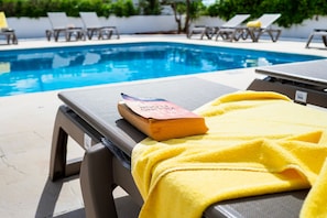 Un espace aménagé au bord de la piscine, avec des chaises longues et des serviettes.