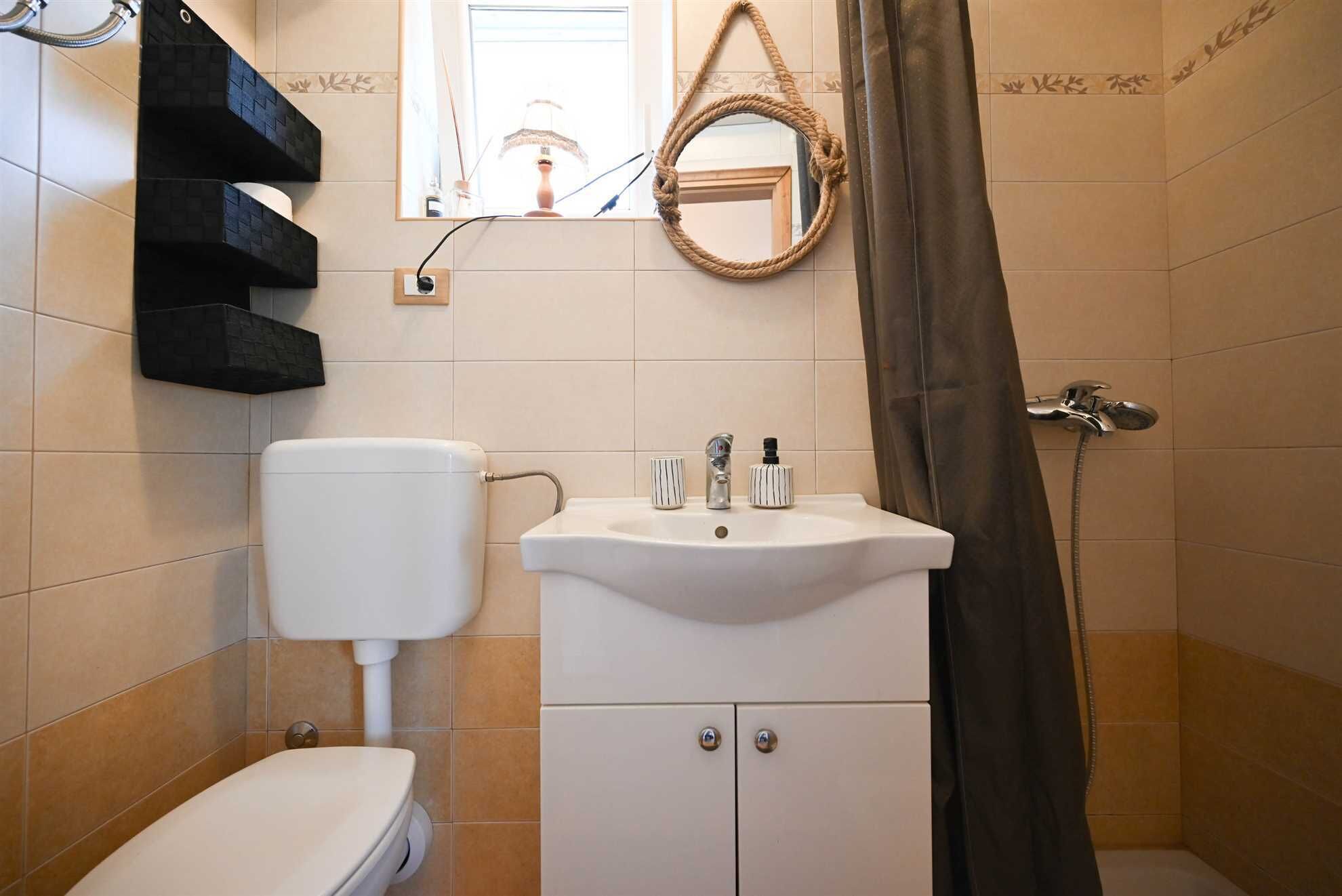A bathroom with a toilet, sink, and shower.