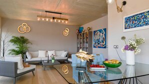 A modern living room with a sofa, coffee table, and decorative fish sculpture. - Stela Vela Apartment (Rovinj)