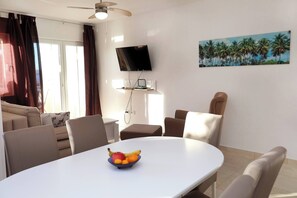 A dining area with a table, chairs, and a fruit bowl. - Apartment Stella Maree 1 (Okrug)