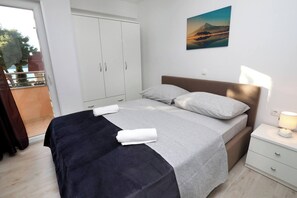 Ein Schlafzimmer mit Bett, Nachttisch, Kleiderschrank und einem Bild an der Wand.
