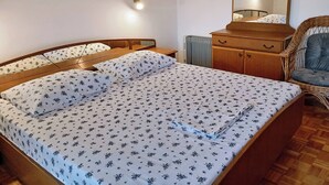 Une chambre à coucher avec un lit, une commode, une chaise et un miroir.