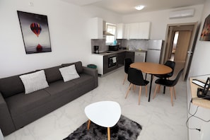 Eine moderne Wohnung mit Wohnbereich, Küche und Essbereich.