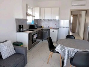 Eine kleine Küche mit Essbereich, einer Couch und einem Tisch.