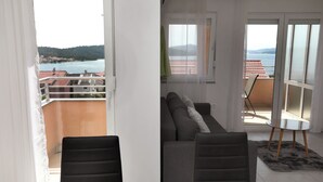 A balcony with a sofa and chairs, a table, and a view of the sea and hills. - Nice 2 Bed Apartment (Okrug)