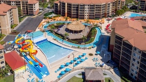 A resort with a large pool, water slides, and multiple buildings. - Large 2-bedroom in resort near Universal Studios & Disney with water park (Orlando)