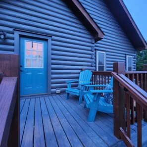 A log cabin with a blue door, two windows, and a deck with two blue Adirondack chairs. - ⭐️ New ⭐️ RidgeCrest Lodge: Retreat w Mountain Views - HUGE 1st Renter Discount  (Landrum)