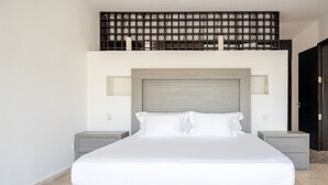 Ein modernes Schlafzimmer mit einem großen Bett, zwei Nachttischen, einem Holz-Kopfteil und einer schwarzen Trennwand über dem Bett.
