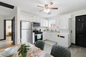 A modern kitchen with white cabinets, a microwave, a stove, and a dishwasher. - Sleeps 4, minutes from beach & Naval base (Norfolk)