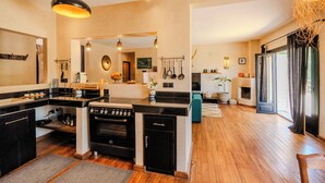 A modern kitchen with a central island, built-in oven, and a dining area with a view. - Charming Villa with private pool and maid (Essaouira)