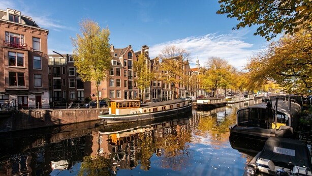 Een gracht met gebouwen aan één kant en een boot afgemeerd aan de overkant.