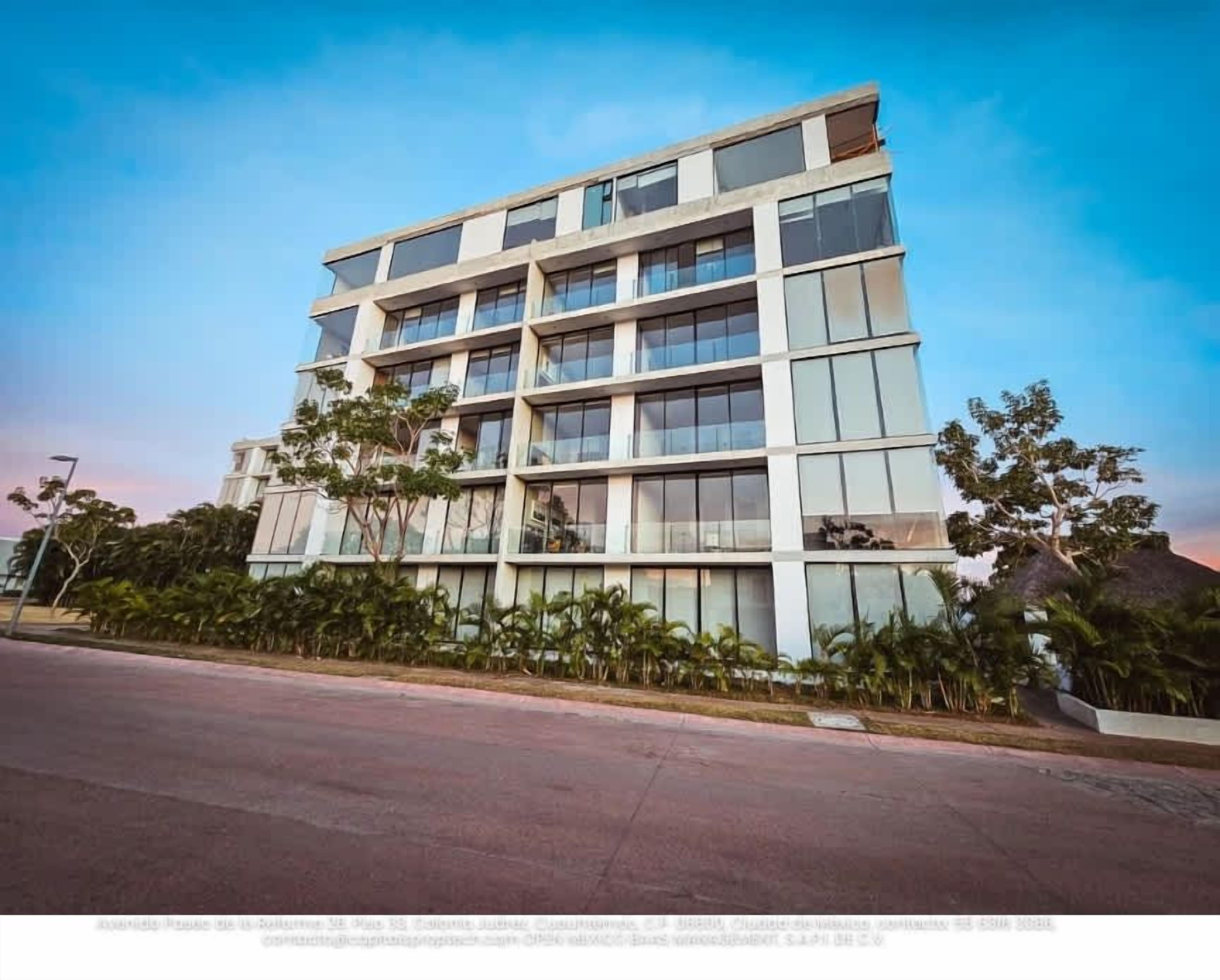 A multi-story building with a modern architectural design, featuring a series of balconies and large windows.
