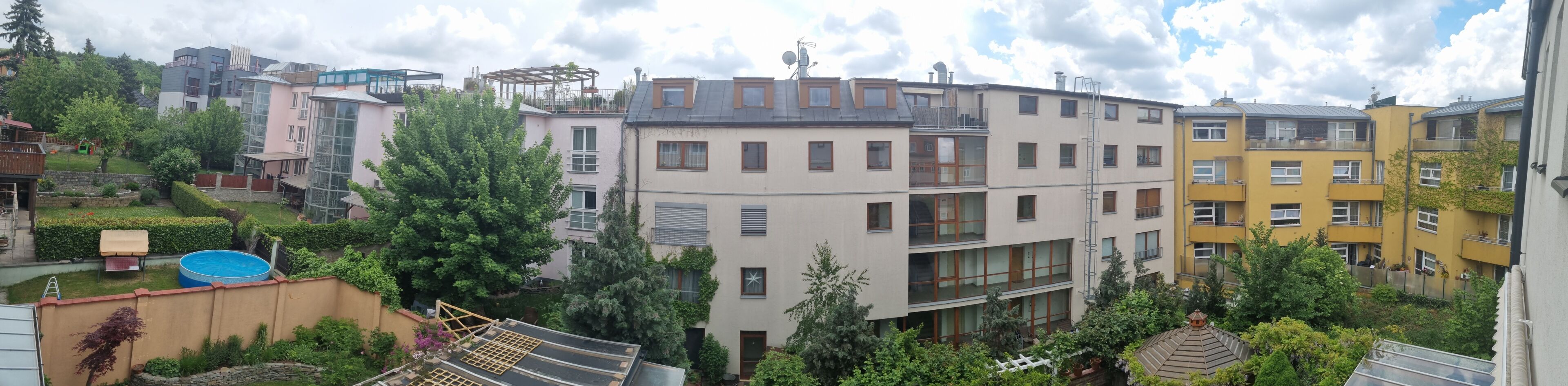 Un edificio residenziale con diversi piani, balconi e una piscina in primo piano.