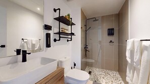 Ein modernes Badezimmer mit einer großen Badewanne, Toilette und Duschbereich.
