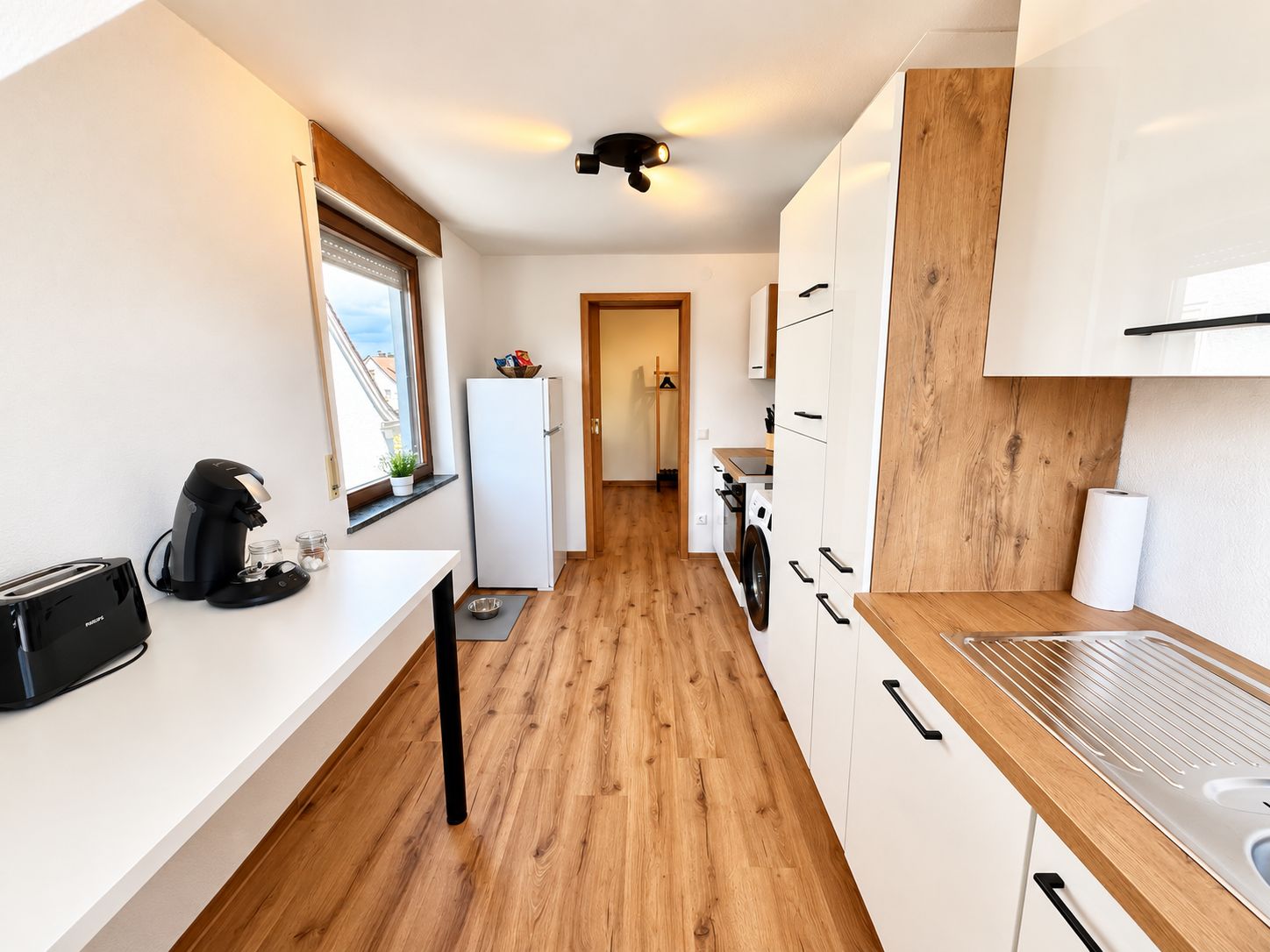 Cocina pequeña equipada con tostadora, hervidor y refrigerador.