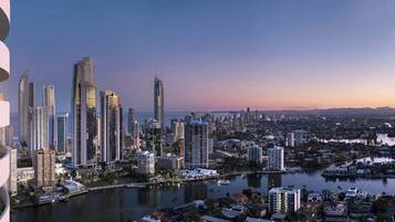 Ein modernes Hochhaus mit Glasfassade, ein Fluss und eine Skyline im Hintergrund.