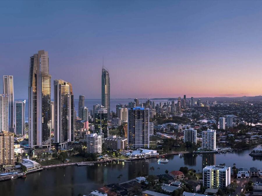 Ein modernes Hochhaus mit Glasfassade, ein Fluss und eine Skyline im Hintergrund.