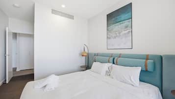 Een hotelkamer met een bed, een schilderij, een lamp en een kast.