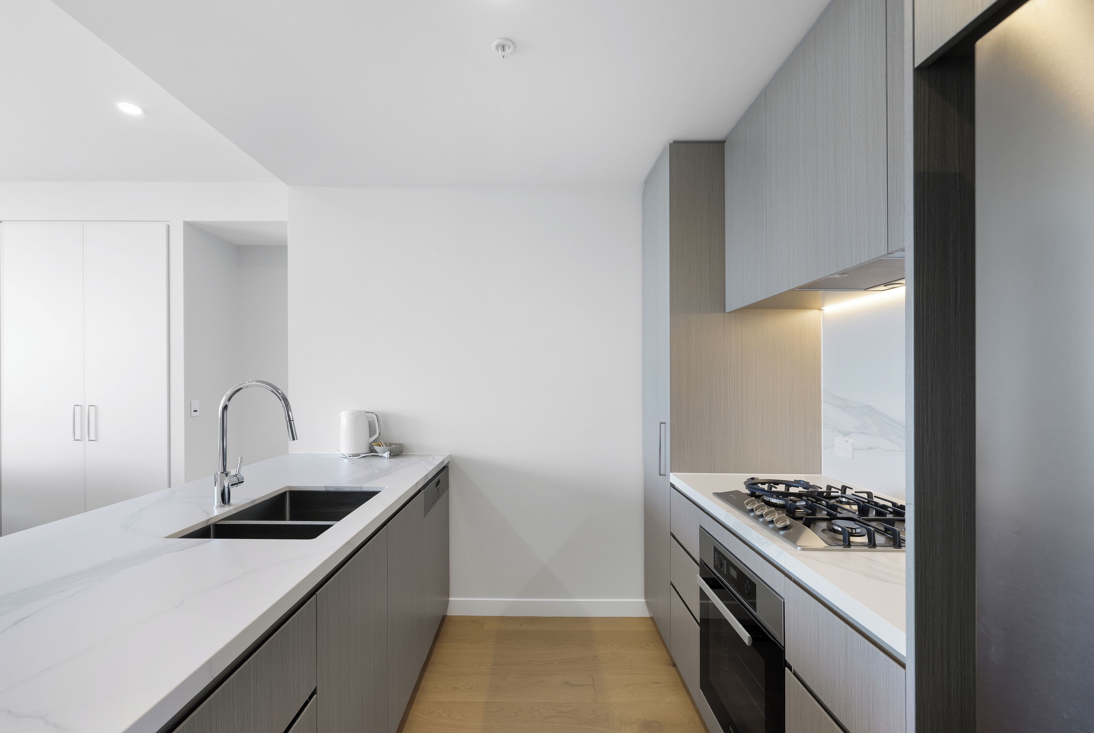 A modern kitchen with a built-in sink, stainless steel faucet, and a gas stove.