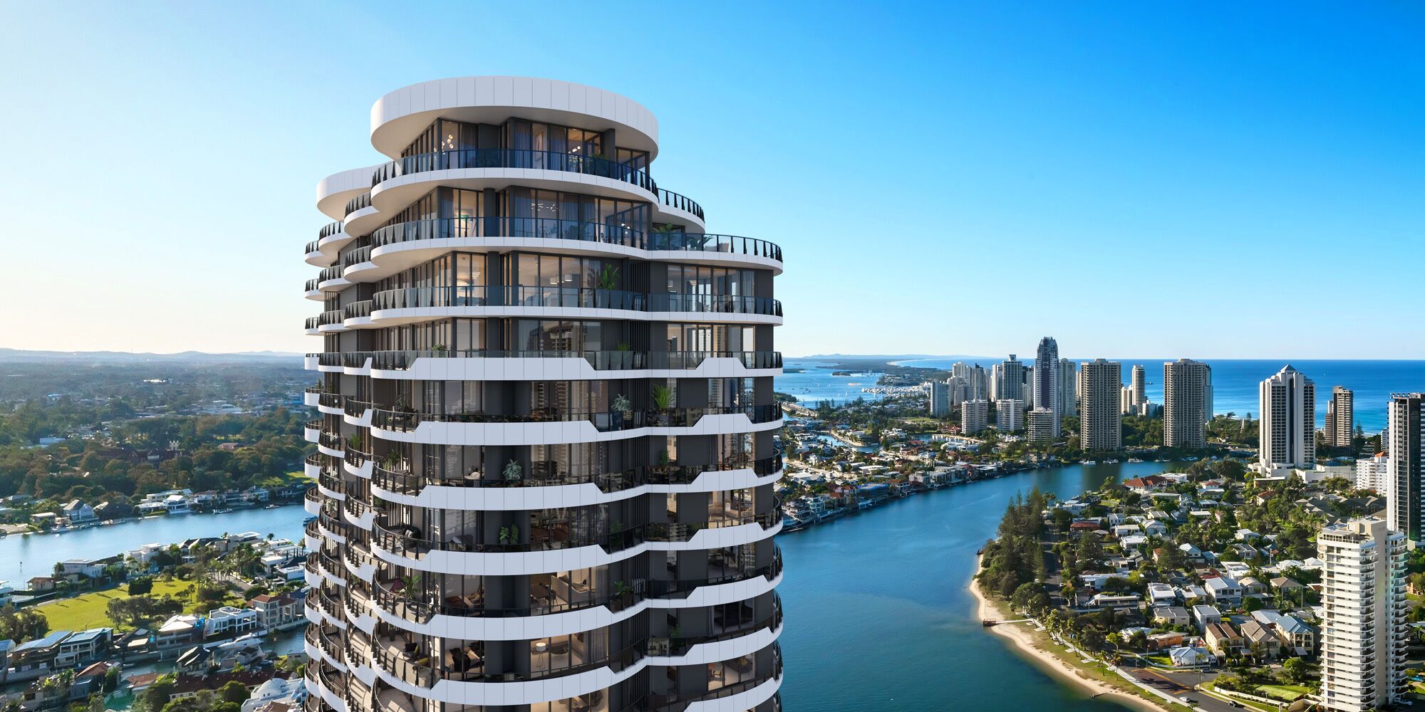 A high-rise building with multiple balconies, a river, and a coastal cityscape.