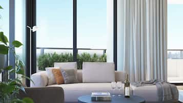 A modern living room with a sofa, coffee table, and a view of the city.