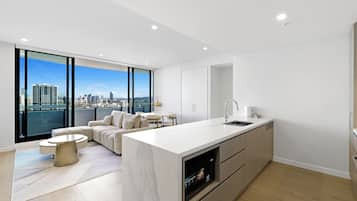 A modern kitchen with a large island, a dining area, and a sofa.