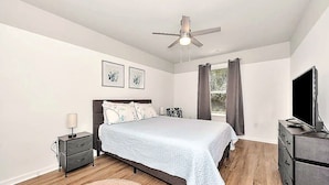 A bedroom with a bed, a nightstand, a dresser, a ceiling fan, and a window with curtains. - Bright 2BR/2BA Home. Large Backyard, 5 Gig Fiber. Nr. VBC, Arsenal, Space Center (Huntsville)