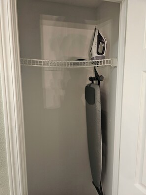 Un baño con cortina de ducha blanca, toallero y una toalla colgada en la pared.