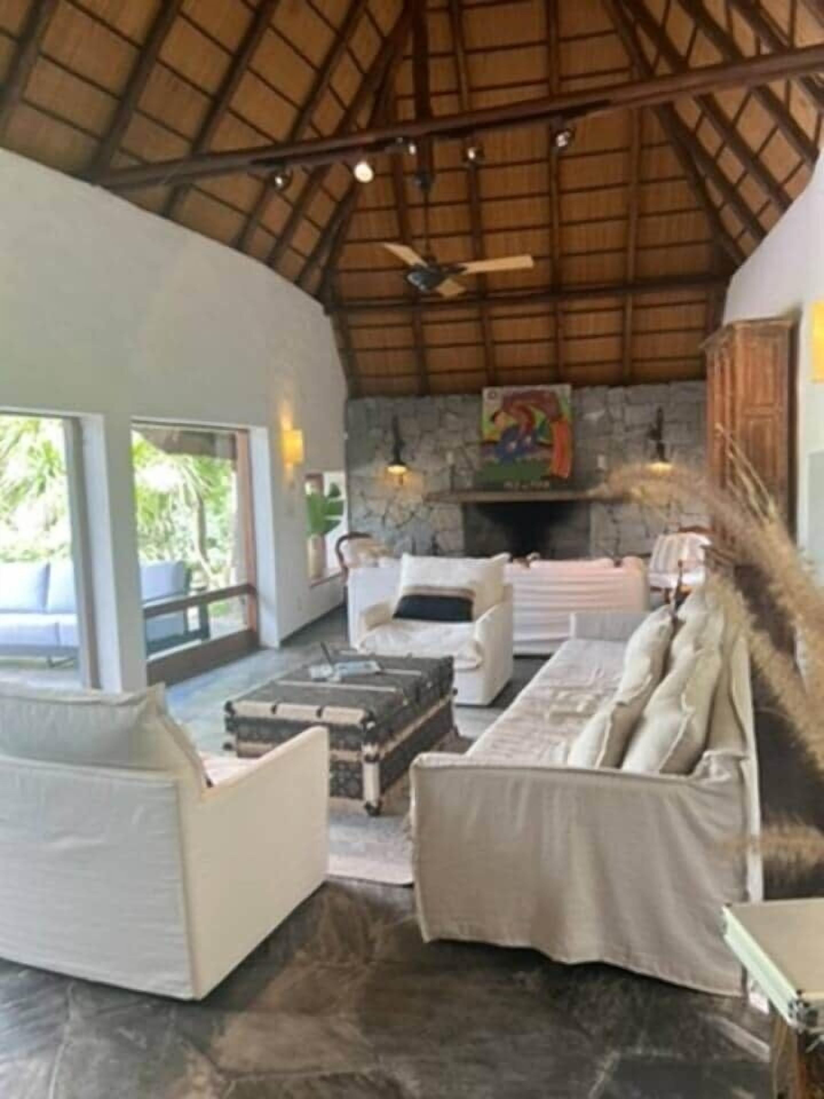 A grand living room with large moveable windowed doors.  2 fireplaces and 15 foot ceilings.  Very light and bright.  Look out onto the pool and huge lawn.