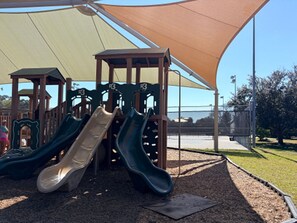 A playground with slides and a shaded area. - Cozy Florida Retreat | Pool | Beach | Comfort (St. Augustine)