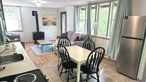 Une cuisine équipée d’une cuisinière, d’une table à manger, de chaises et d’un réfrigérateur.