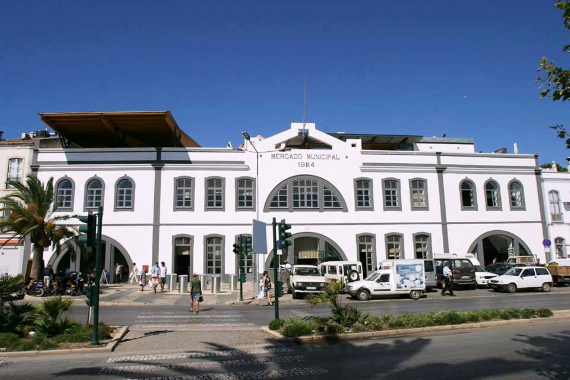 A white building with arched windows and a sign reading 'MERCADO MUNICIPAL 1924'.